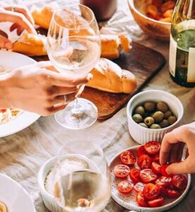 Italian dinner table with person holding wine glass